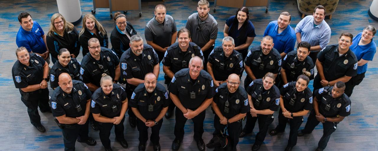 Group of police officers and civilian staff looking up at photographer